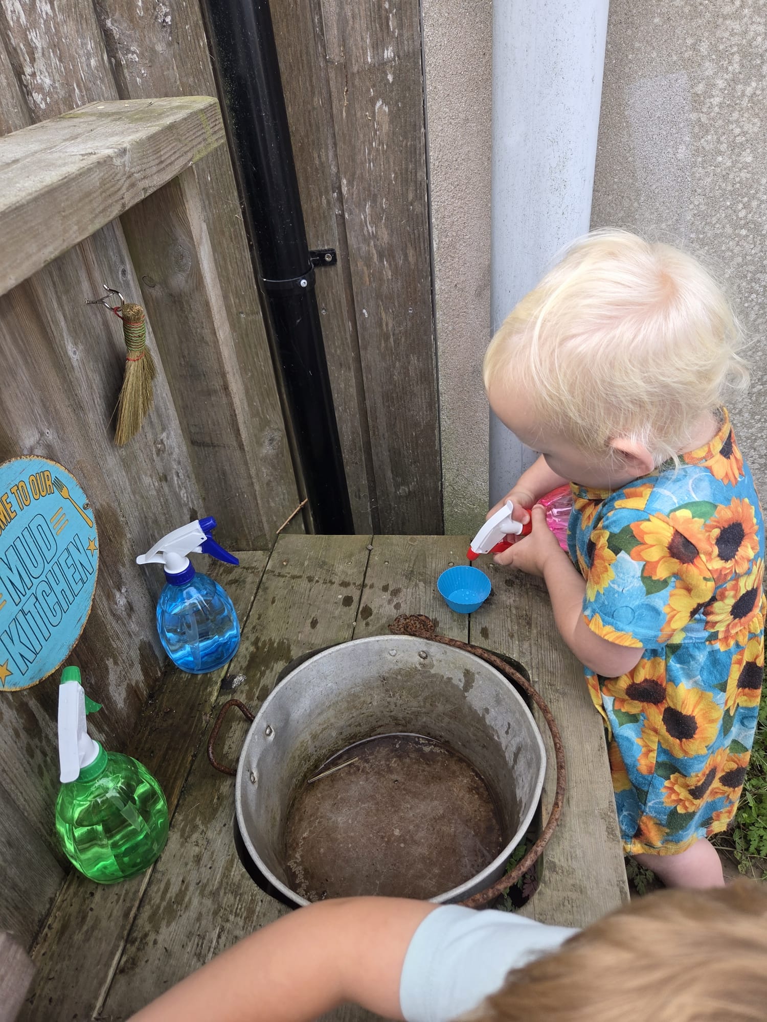 Child enjoying mud kitchen play at Brambles Nursery